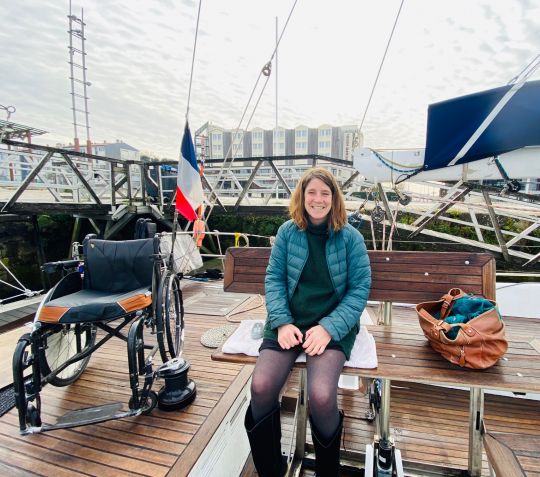 Olivia sur le banc rail électrique lui permettant d'accéder au carré et se diriger vers l'intérieur du bateau - @ajitecrew