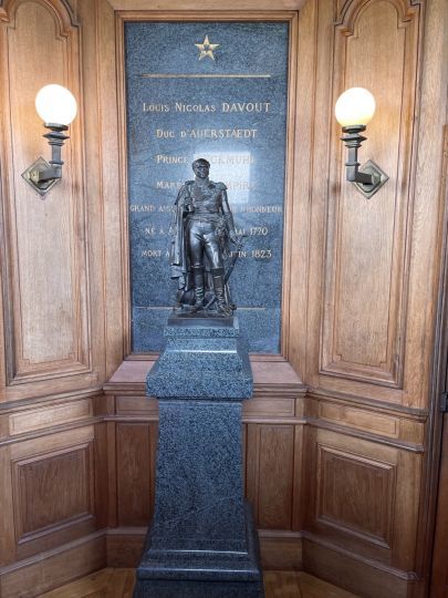 La statue en bronze du maréchal Davout en tenue d'apparat trône sur son socle en porphyre