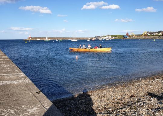 Baigneurs et barques se croisent dans le port de Wicklow