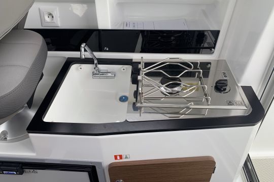 La cuisine avec son réchaud à gaz, évier et réfrigérateur