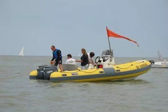 Was bedeutet die orangefarbene Flagge, die ber dem Boot weht?